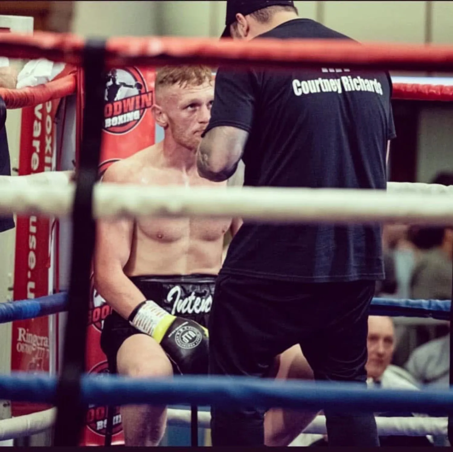 Boxer in Intense shorts listening to corner instructions